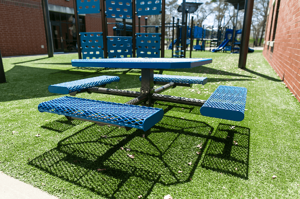 Inground mounted picnic table with steel frame embedded into concrete footing providing permanent outdoor seating solution for parks and public spaces